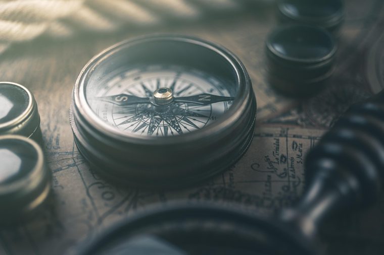 A vintage compass resting on an old map