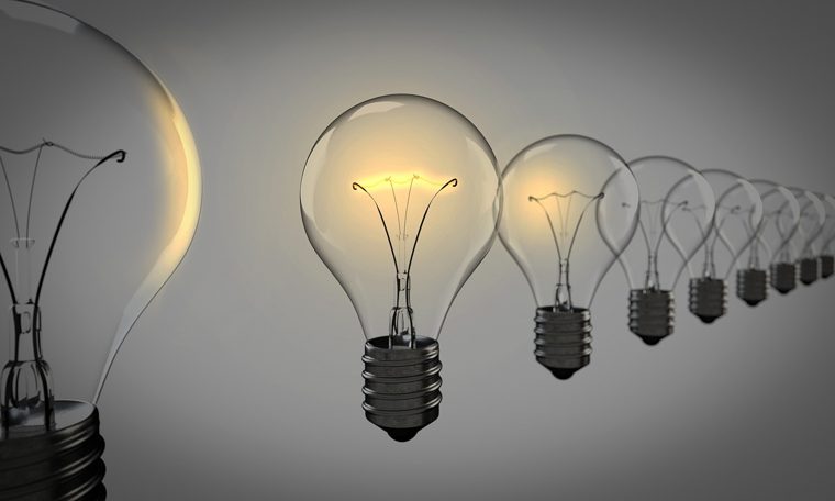 A row of light bulbs growing larger and brighter towards the viewer