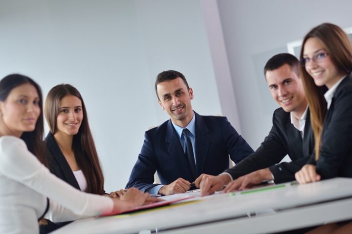 A smiling team seated around a table