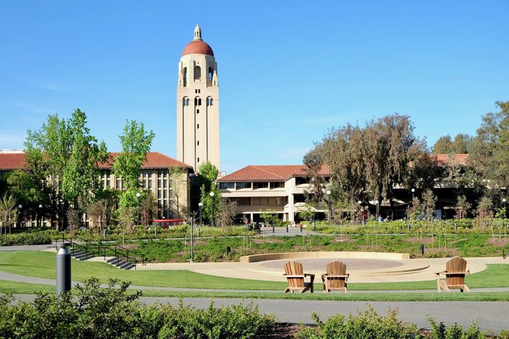 A university campus with a tall clock tower and lawns