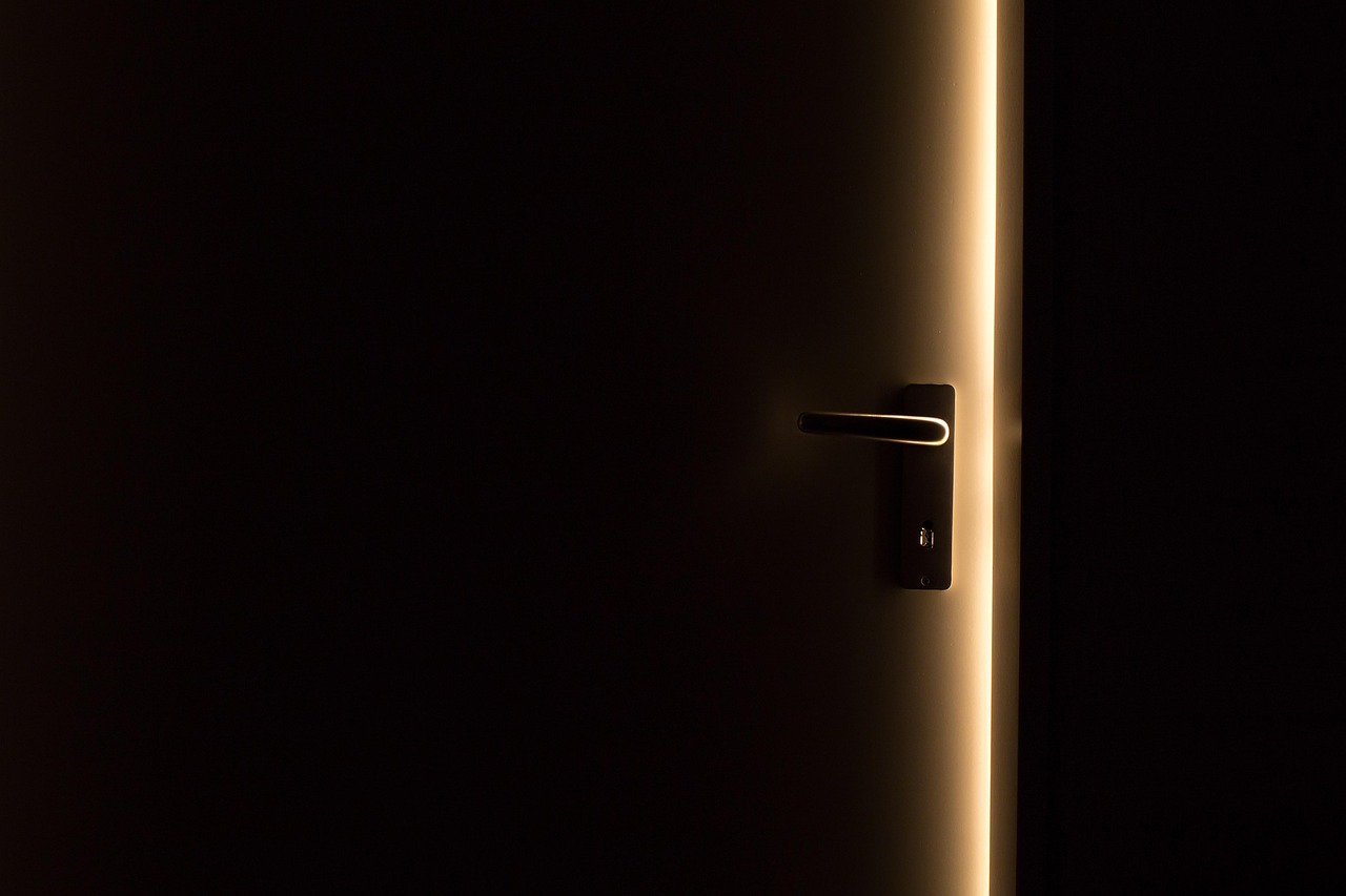 A door standing slightly open, with light shining through the gap