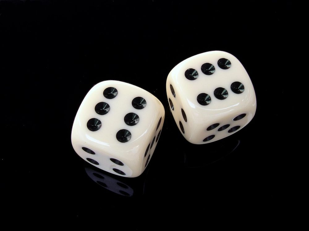 A pair of white dice on a black background