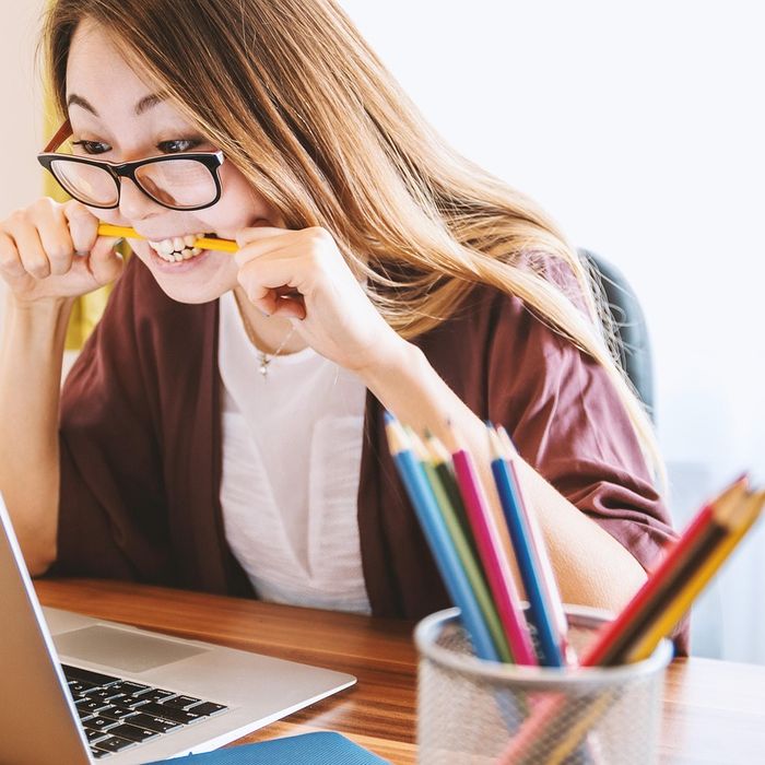A student thinking while working at a laptop